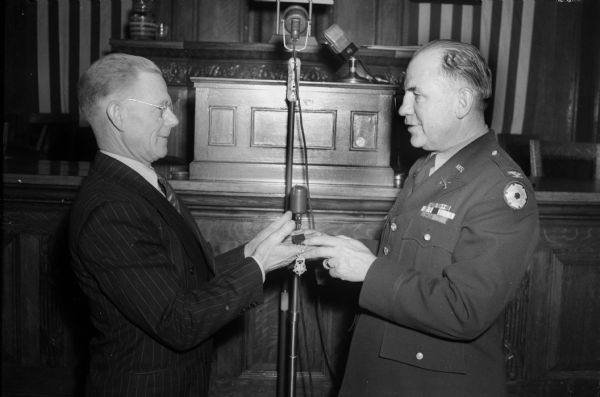 Axel Olson, father of Sgt. Truman O. Olson, deceased, receiving the Congressional Medal of Honor from Col. W. Lutz Krigbaum on behalf of his son, who was killed at Anzio, Italy, during World War II.