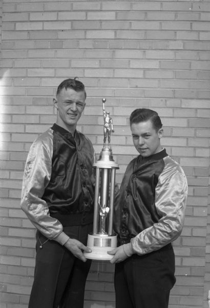 Steve Slattery and John Eichman, co-captains of the 1945 Crusader cage team, hold the trophy awarded to the winners of the annual St. Norbert College State Catholic basketball tournament.