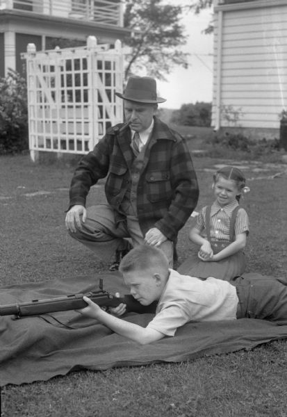 Ira Kurth, 3918 Manitou Way, with children Stuart and Kathleen. Stuart is aiming a gun while his father and sister look on.
