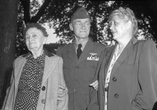 Vice-Admiral Marc A. Mitscher stands with his mother, Mrs. Oscar A. Mitscher (left), and smiles at his wife, Frances Smalley Mitscher, after a reunion at his birthplace, the first time he had visited Hillsboro in a decade.