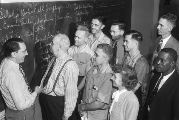 University of Wisconsin School for Workers, group of students and teacher standing, looking at bulletin board with list of classes/topics.

In 1945 the University of Wisconsin School for Workers conducted three institutes: a general institute, an institute for AFSCME members and an industrial relations institute for church leadership.