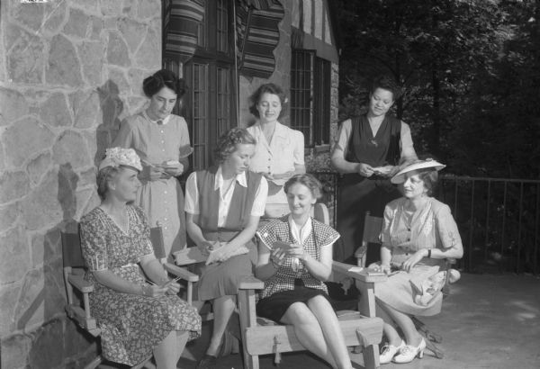 Seven women committee members plan a benefit program sponsored by the Joint Anti-Fascist Refugee Committee in the home of Mrs. Grant (Esther) Haas, 1518 Sumac Drive. The women sitting left to right are: Mrs. Hans (Theresa) Reese, Mrs. Harold (Hjordis) Wolfe, Mrs. Karl Paul Link, and Mrs. Einar (Eva) Haugen. Standing: Mrs. Grant (Esther) Haas, Mrs. Ramon (Eleanor) Coffman, and Mrs. Stanley (Dimetra Taliaferro) Shivers.