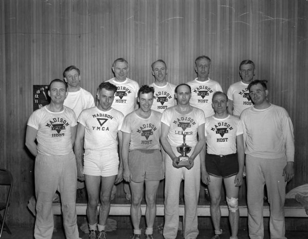 Group portrait of the Madison YMCA men's state volleyball championship team.  (Tournament sponsored by the Board of Education?)
Team members: front row, left to right: Elto Bunge, George Poster, Bob Larson, Joe Dapin, Jim Weibe, and Bill Gersbach; back row, left to right: Dean Morey, Walter Price, Charles Dale, Fred Risser, Sr., and Dewey Edson.