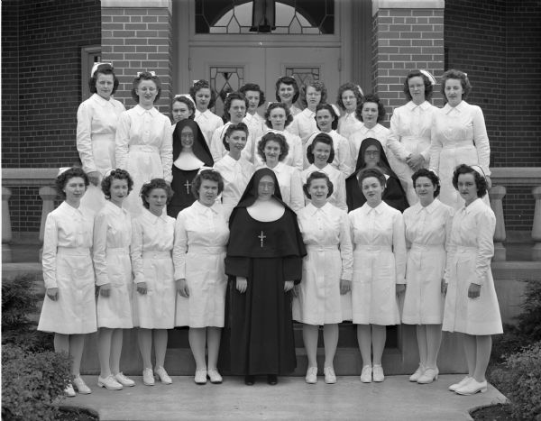 Group portrait of the recent graduates from St. Mary's School of Nursing, shown with Sister Mary James Howard, Director of Nurses.
