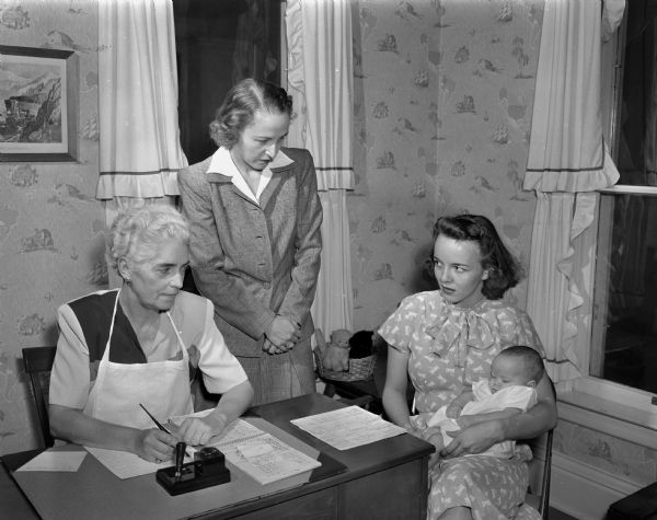 Visiting Nurse Service volunteers, sponsored by Attic Angels, interview Mrs. George (Francees) Urbanis, and daughter Carol Jean, eleven weeks old. Volunteers conducting the interview are Mrs. O.C. Gillette and Mrs. W.J. (Lydia) Bury, Cedarwood Farm.