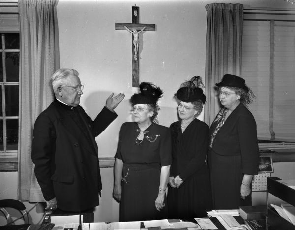 Jennie Conlin, Lilian Regan, and Irene O'Rowley, left to right, members of the Madison Business and Professional Women's Club, interviewing Bishop William P. O'Connor on the matter of "facing the future spiritually."