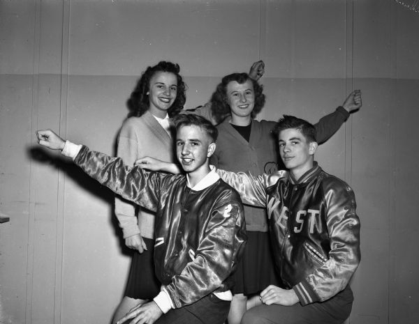 Four Madison high school student cheerleaders in uniform, left to right: Marian Ott, Edgewood, Charles Fassett, Wisconsin, Alice Pertzborn, Central, Bob Roberts, West.