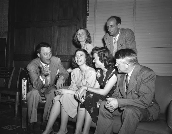 United States Senator, Glen Taylor, at left, with a group of Madisonians at a milk and cookies reception. Seated from left to right: Senator Taylor; Merry Buchanan, 521 North Henry Street; Marge Gaede, 2014 Kendall Avenue, and R.S. Haevenor, 1710 Adams Street. Standing left to right: Mrs. Karl Paul Link, the Highlands, and Merl Shipman, 2064 Sundstrom Street, running for assemblyman in the third district. Senator Taylor is the Peoples Progressive Party candidate for vice-president in the fall election.