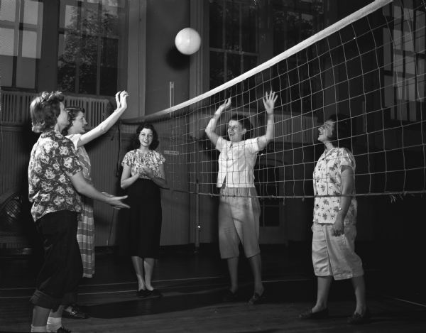 Members of the YWCA's Teen and Twenty club playing volleyball. Shirley Taubert, 2515 Kendall Avenue, center, is keeping score. Players are, left to right: Phyllis Bryant, Route 3, Mary Kruel, 143 North Hancock Street, Iris O'Connell, 2034 Rusk Street, and Rosalie Kerl, 2514 Chamberlain Avenue.