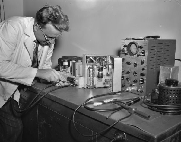 Assistant Professor Verner Suomi of the University of Wisconsin Meteorology department shown adjusting part of the dew-point moisture indicator which he invented and which is being built in the meteorology laboratory.