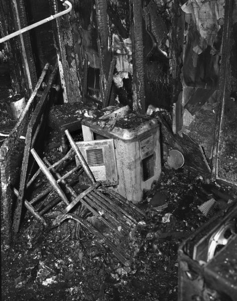 Week-old oil heater which exploded and caused the fire in the tenement-type house at 15 South Bedford Street, which is located at the rear of the city garage. Florence Dinger and three of her children were killed.