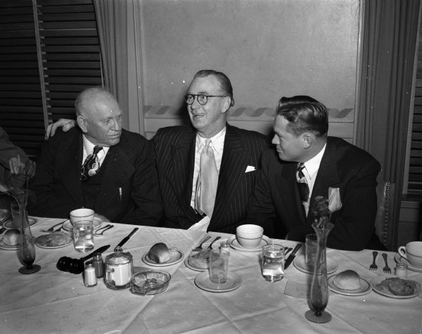 "Roundy" Coughlin sitting between retired Police Chief William H. McCormick (left) and his successor, Chief Bruce Weatherly, at a testimonial dinner for the retired chief at the Elk's Club.