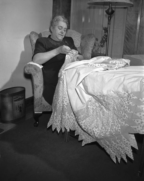 Mrs. Earle S. (Edith) Metcalf sewing a Rainbow Star quilt at her home at 3905 Council Crest. It is her nineteenth quilt.