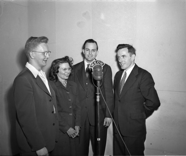 Standing before a WKOW microphone are, left to right: Arthur Olson, and Mrs Henry (Ruth) Czerysinski, members of the First University Church choir,  Allan P, McCaul, associate minister of First University Methodist Church, and Rev. Richard E. Pritchard, committee chairman and pastor of Westminster Presbyterian Church. The photograph appeared in an advertisment to publicize a new religious radio program, sponsored by Wisconsin Council of Churches, to be broadcast on radio station WKOW.