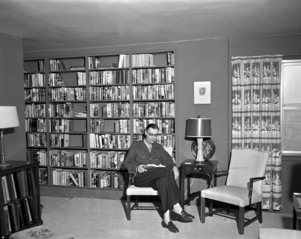 Edgewater Hotel Apartment T.L. Graham reading in front of the floor to ceiling bookcases in the living room of his Edgewater Hotel apartment in Madison. The Edgewater Hotel is located at 666 Wisconsin Avenue.