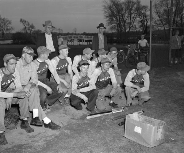Members of the Philgas softball team watching play during a Mendota League game in Vilas Park.