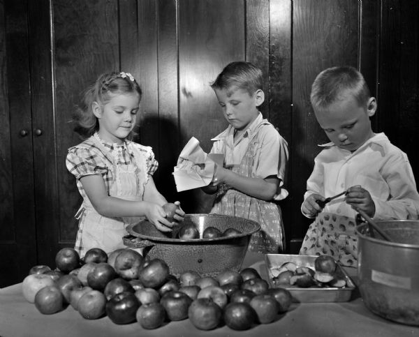 Randall Elementary School kindergartners are shown making applesauce under the supervision of their teachers Marguerite Drew and Lois Griskavich. Left to right: Virginia Ann Hoffman, daughter of Mr. and Mrs. Arvid Hoffman, 2653 Stevens Street; Michael Hinn, son of Mr. and Mrs. William Hinn Jr., 1605 Chadbourne Avenue, and Bernard Purdy, son of Mr. and Mrs. Hearld Purdy, 1 North Hillside Terrace.