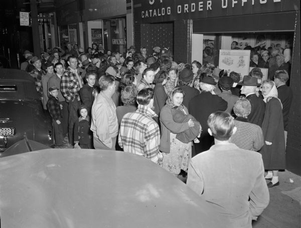 Spiegel Catalog Order Office Crowd of shoppers in front of Spiegel's Catalog Order Office, 427 State Street. Also shown are Bluteau's Wholesale Market, 421 State St. & Mack-Olson Food Shop, 425 State St.