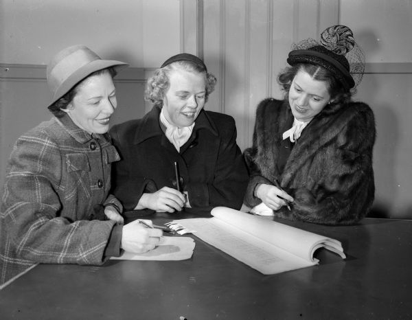 Three members of the League of Women Voters check the voter poll lists to see who has not yet registered to vote. Left to right: Mrs. Arthur P. (Julia) Miles, 20 North Spooner Street; Mrs. Alan W. Roecker, Route 5; and Mrs. Willliam Shannon, 1105 Rutledge Street.