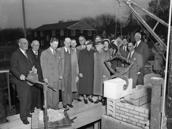 The Reverend Charles R. Bell Jr., pastor of the First Baptist Church, is assisted by a group of church officials as he lays the cornerstone for the new building on 530 North Franklin Avenue. Pictured left to right: Professor John L. Gillan, former pastor Rev. A.T. Wallace, Rev. Bell, W.L. Woodward, H.L. Rasmussen, E.H. Mueller, Mrs. Bert (Isolene) Studebacker, C.A. McElmurry, Mrs. D.H. Otis, Betty Jane Erickson, Edith Anderson, Homer Stahl, architect Allen Strang, and university pastor George L. Collins.
