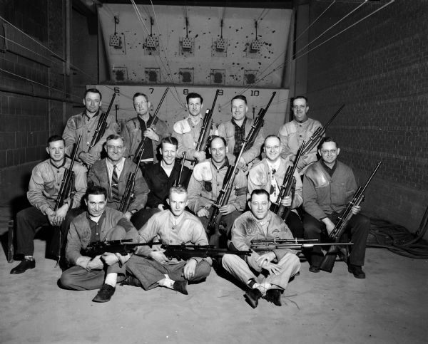 Group portrait of seventeen members of the Madison Rifle club holding their rifles. They repeated as champion of the Southern Wisconsin Rifle League by winning 13 of 15 matches during the recently completed season. Two members of the championship squad are missing from the portrait.