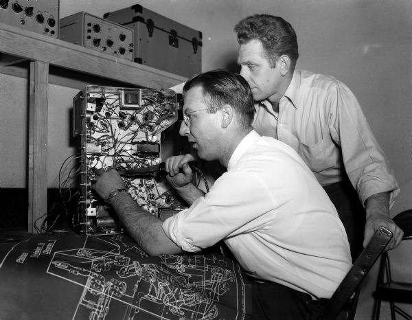Jim Studee, left, and Gordon Jenkins, students in the television repair course offered at the Madison Vocational and Adult school, build a television set. The activity is part of the course work for television repairmen.