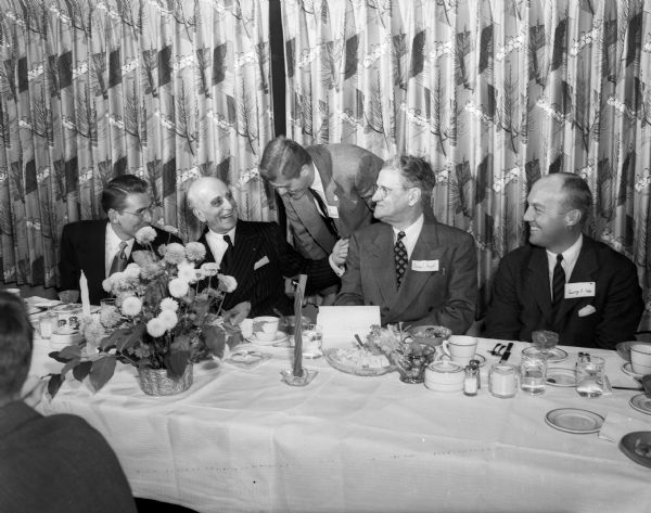 Joseph E. Davies (second from the left), one-time U.S. ambassador and graduate of the University of Wisconsin, receives congratulations at a dinner after being installed into Phi Delta Phi, the University law fraternity. Other men at the table are Thomas H. Lucas, fraternity president, Walter Raushenbush, George I. Haight, Chicago legal advisor of the Wisconsin Foundation, and George P. Hoke, Minneapolis district supervisor of the fraternity.