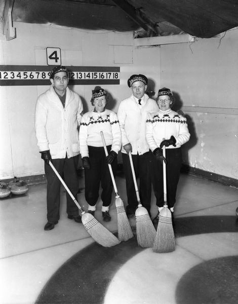 Bud Leonhard, Mrs. Mildred Solheim, Rag Onstad, and Mrs. Esther Onstad, members of the Rag Onstad curling rink of Madison, posing at the second annual mixed bonspiel sponsored by the Portage Curling Club.