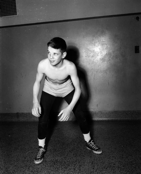 Portrait of East High School wrestler, Billy Gorman, shown standing in a beginning wrestling pose and wearing wrestling clothes. Billy Gorman was 103 pounds and 5 feet tall and had seven consecutive victories.