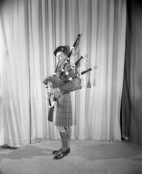 U.W. International Club Costume Ball William Chipman, a participant at the University of Wisconsin International Club Costume Ball, wearing an authentic Scottish Royal Stuart costume and playing a bagpipe.