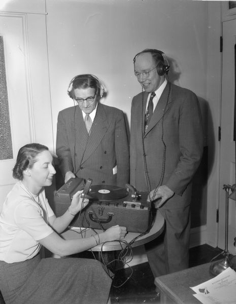 Dr. Marie Brittin, at left, demonstrates the electronic "train-ear" to Bernard Gill, center, and Kenneth Snee, right, fund chairman and executive secretary respectively of the Wisconsin Association for the Disabled, in the Easter Seal Cerebral Palsy center. The equipment was given to the center by Roundy's Fun Fund.