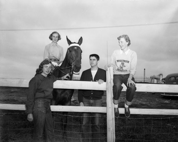 Wisconsin Hoofers Horse Show Four University of Wisconsin students who will participate in the horse show sponsored by the Wisconsin Hoofers. Left to right are Joan Adler, Unionville, New Jersey; Patricia Snyder, Oak Park, Illinois (on the horse); John Brkich, Milwaukee; and Ann Wegner, Milwaukee.