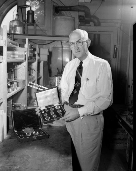 Professor Richard C. Emmons, of the University of Wisconsin Geology Department, who is holding a gem case of glass replicas of 10 of the largest and best-known diamonds in the world.