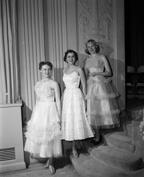 As part of Co-ed's Week, an event designed to combine features of special interest to college women, three U.W. co-eds model new spring fashions in formal dress. Left to right: Joan Bjorquist, Milwaukee, Connie Schardt, Milwaukee, and Sandra Brecke, Wauwatosa. The event is sponsored by the U.W. Associated Women's Student organization.