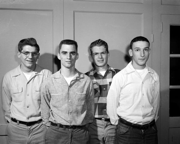 Hi-Y Workers Four members of the Madison Hi-Y work on projects to help visitors who are coming to Madison for the state basketball tournament. Left to right are Merle Manion, Phil Behrend, Dick Wills, and Al Lerner.