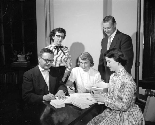 Mrs. Walter (Margaret) Fauerbach, Jr. and John Lang work on invitations to Edgewood High School alumni for an all-class reunion. Seated are Dave Heilman, Joan Farrell and Mary Macken.
