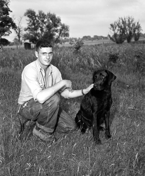 John Detienne of Milwaukee posing with his dog, Cinders of Erin. The dog was a champion in the Wisconsin Retriever field trials at Westport.