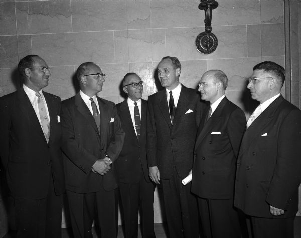 Group portrait of Governor Walter Kohler with five Jews observing the 300th anniversary of the September 1634 arrival of Jewish settlers in New Amsterdam, now New York. Shown in the Wisconsin State Capitol, left to right, are: Rabbi Arthur Brodey, Kenosha; Norman Abraham, Milwaukee, tercentennial state chairman; Harry Epstein, Madison chairman of the celebration; Governor Kohler; Rabbi Joseph L. Baron, Milwaukee honorary state chairman, and Rabbi Manfred Swarsensky of Beth El Temple, Madison.