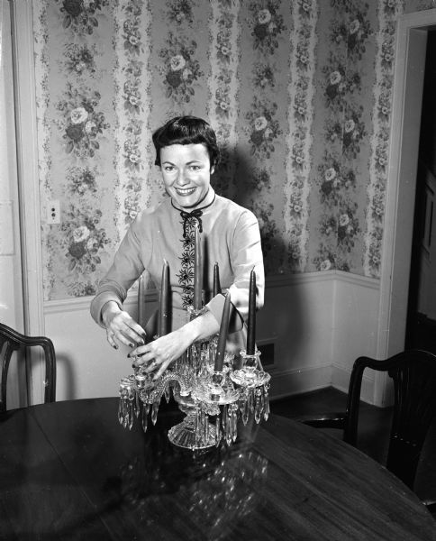Audrey Walsh arranges an heirloom crystal candelabra in preparation for a University of Wisconsin football pregame party. She plans to serve Swedish meatballs and rice.