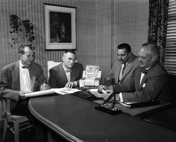 Advertising Shapes American Life Men sitting around a table during a planning session of the Arthur Towell Advertising Agency. From left to right are: James Newhall, art director; Tom Towell, media director; Paul Staedtler, vice president and production manager, and Arthur Towell, president.