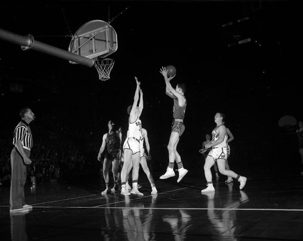 State High School Basketball Tournament Appleton's Jim Ray lets go from the side over the outstretched arm of Jim Schoemer of Kohler (#30) while Jim Boerner (#32) trails the play in Friday night's game at the State High School Basketball Tournament.