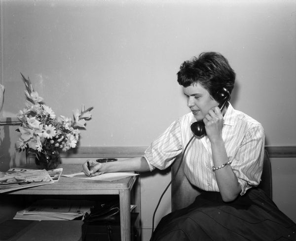 Sue Collins jots down scores she hears transmitted by the new recorder machine as radio station WIBA's automatic telephone system is in operation for the first time.