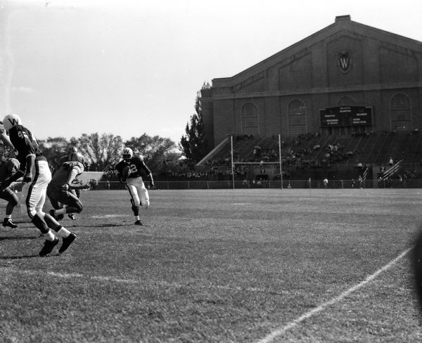 Wisconsin vs. West Virginia Football Game Wisconsin quarterback Sidney Williams (#22) carries the ball against West Virginia in their football game at Camp Randall Stadium. The West Virginia player in the picture is Bill McCure (#44).