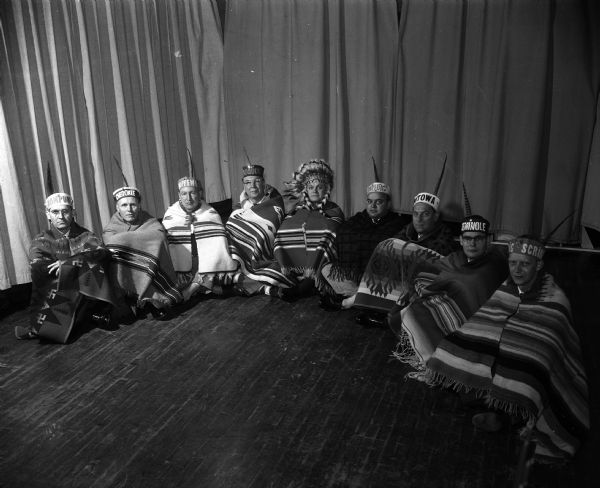 Nakoma Twelfth Night Party The husbands of the "tribe chiefs" of the Nakoma Welfare League dressed in Native American feathers and blankets as a surprise feature at the Nakoma Twelth Night party at the Nakoma school. Left to right are Dwight Forsyth, Robert Paddock, Martin Freck, Charles Wedemeyer, Claire A. Thomas, Horace Wilkie, Howard Poehling, Charles Rauschenberger, and Gordon M. Findorff.