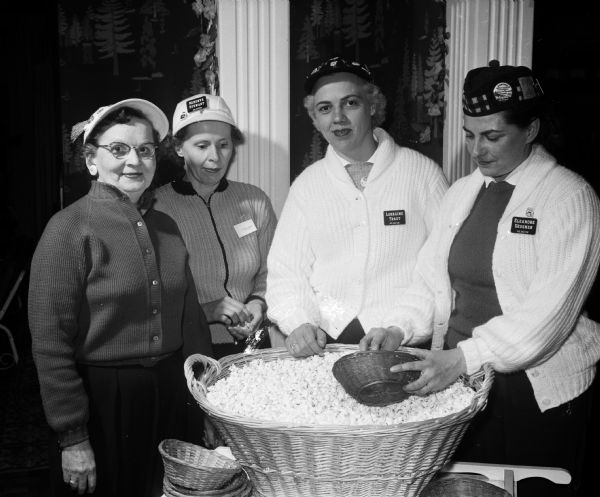 Peg Caldwell (left), Minerva Stewart, Lorraine Traut and Eleanore Gessner enjoy baskets of popcorn before the Badger Bonspiel banquet.