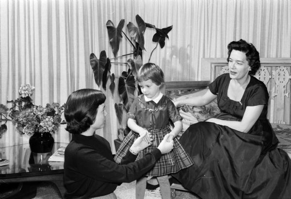 Red Cross Blood Donor Recipeint Three year-old Louise Runge, center, whose life was saved by the blood of an unknown Red Cross donor, is shown with University of Wisconsin student Nancy Stephenson, chairman of the campus bloodmobile drive, left, and Elizabeth Runge.