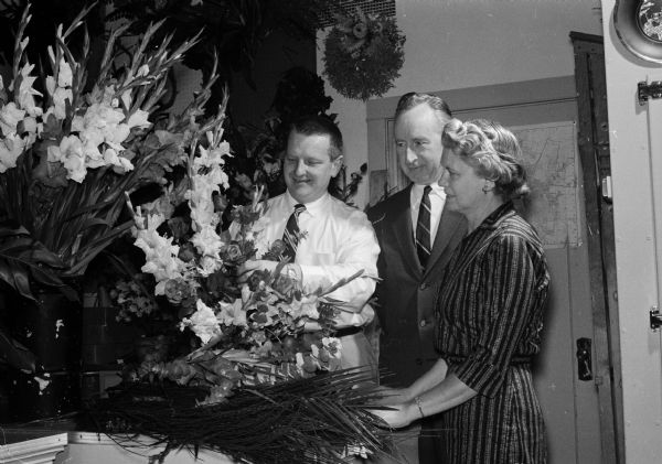 South Central Florist Association Aids Cancer Crusade Florists of the South Central Florists' Association will create floral arrangements in the windows of the Wolff, Kubly and Hirsig store. These arrangements will be auctioned off and the proceeds will be given to the Dane County Cancer Crusade. From left to right are: Al Felly, president of the South Central Florists' Association; former Governor Vernon Thomson, city-county Cancer Crusade chairman; and Marcelle Gill, a commentator. The commentators will describe to the public how the floral arrangements are being assembled.