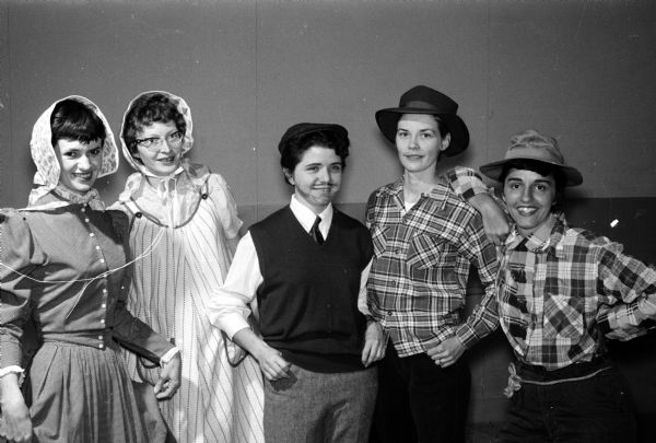 A scene from a variety show is put on by University of Wisconsin Dames Club units. Using a hillbilly theme, members of the Gadabouts created a musical skit, "Moonshine On Tobacco Road". Skit players include, left to right: Mrs. James Martinsen, Mrs. Wilford Elliott, Beverly Hermensen, Mrs. Thomas Ehrmann, and Ann Gianakaris.