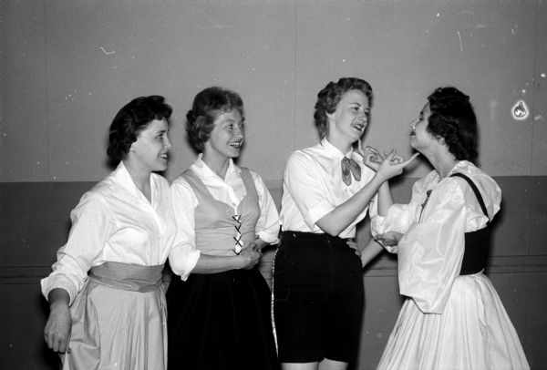 Dancers in three German folk dances given by the the Badgerettes unit include, left to right: Caroline Doersch, Mrs. Dean Hoppmann, Marlene Smedema, and Arlene Ellingson. The dances were a part of a variety show put on by University of Wisconsin Dames Club units.