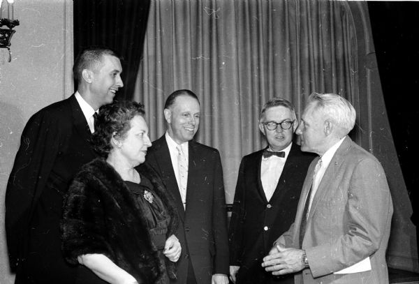 W. Earl Hall (right), editor of the Mason City, Iowa Globe-Gazette, is the main speaker at the 50th anniversary meeting of the Dane County chapter of the Red Cross. Talking with him are, left to right: Phillip C. Stark, outgoing chapter chairman; Constance and Conrad A. Elvehjem, University of Wisconsin President; and Professor Robert Taylor, anniversary committee chairman.